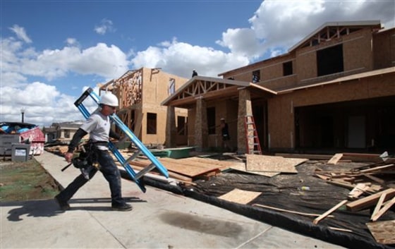A construction worker carries a ladder to a home under construction April 5 in Sacramento, Calif. 