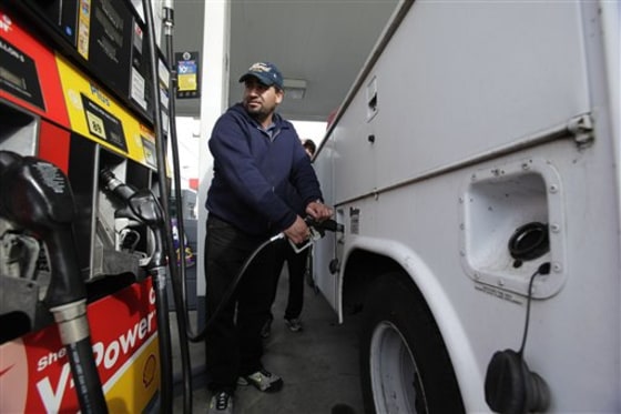 A motorist fills up at a Shell gas station in Seattle. The economy slowed sharply in the first three months of the year as higher gasoline prices cut into consumer spending.