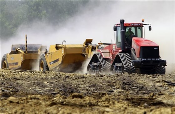 Construction workers break ground on an industrial park complex in Springfield, Ill. The U.S. economy grew at a much slower pace this spring than previously estimated, new data show.