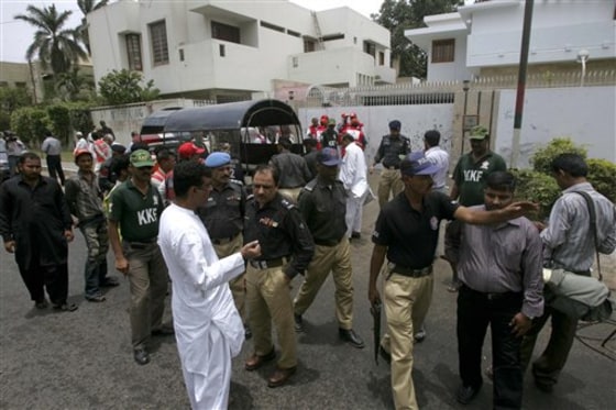 Pakistani police officer gather at the site of an explosion outside the office of International Committee of the Red Cross in Karachi, Pakistan on Saturday, June 25, 2011.