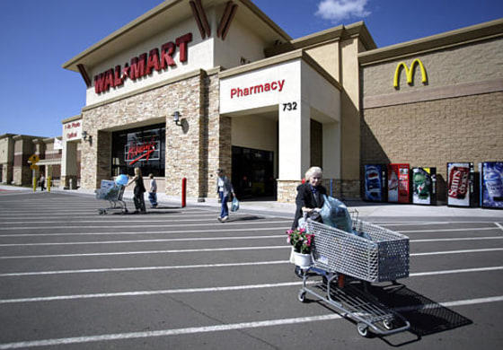 Shoppers exit a Wal-Mart store in San Marcos , Calif. The world's largest retailer blocked a proposed ban of its superstores in Contra Costa County, Calif., but lost a vote that could allow it to open another store in San Marcos. It has faced strong opposition in California to its strong plans for expansion.