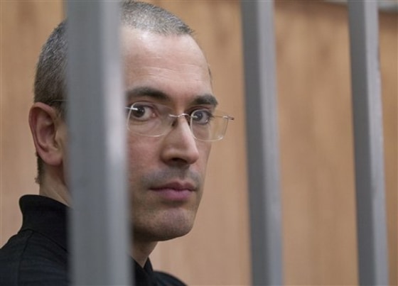 Platon Lebedev, left, a business associate of Yukos' ex-CEO Mikhail Khodorkovsky, speaks from a defendant's cage with his lawyer Yevgeny Baru at a courtroom in Moscow Monday.