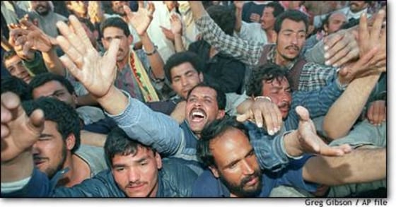 Iraqi refugees swarm around a truck where Saudi soldiers were distributing food at a makeshift refugee camp near Safwan, Iraq, along the Kuwaiti-Iraqi border in 1991. U.N. aid agencies are drawing up plans in case there is a repeat crisis.