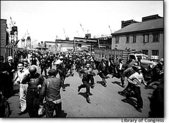 Workmen at Baltimore's Bethlehem-Fairfield shipyards run to punch the clock at the end of their shift in May 1943.