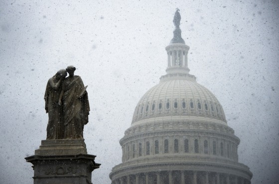 Snow begins to gather on a statue outside the Capitol Building in Washington, DC, Dec. 10, 2013.