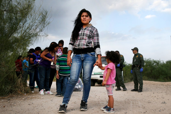 Honduran immigrants wait as a Border Patrol vehicle arrives to transport their group to a processing center, July 24, 2014 in Mission, Texas.