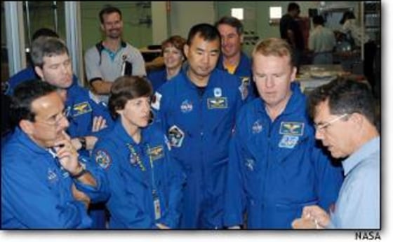 Wearing blue flight suits, astronauts listen to manager Jeff Andress. From left are Charles Camarda, Stephen Frick, Wendy Lawrence, Eileen Collins, Soichi Noguchi, Stephen Robinson and Andrew Thomas. All but Frick are to fly on STS-114, along with James Kelly (not pictured).