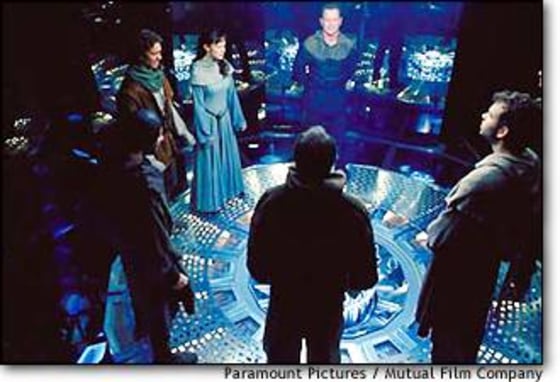 Dressed in medieval garb, a team stands inside a machine that will transport them to 14th-century France, in "Timeline."