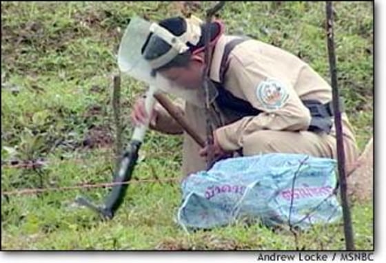 A Vietnamese soldier, trained in the latest de-mining techniques, searches for unexploded bombs and other ordnance in a field outside of Dungha.
