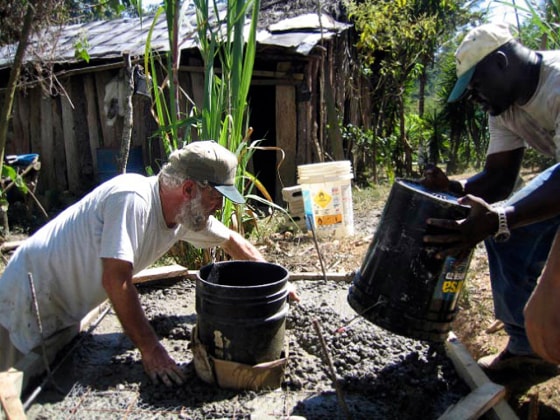 Mike Wood, left, and Nana Mensah are seen filling in the cement base of a composting latrine on Feb. 24, at a farm in Terreritos, Honduras. The assistant high school principal is one of several Americans who have volunteered their vacations for a charitable or humanitarian purpose.