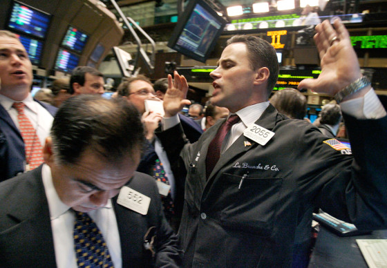 Image: Specialist Jason Hardzewicz, right, calls out prices for AT&T at his post on the floor of the New York Stock Exchange