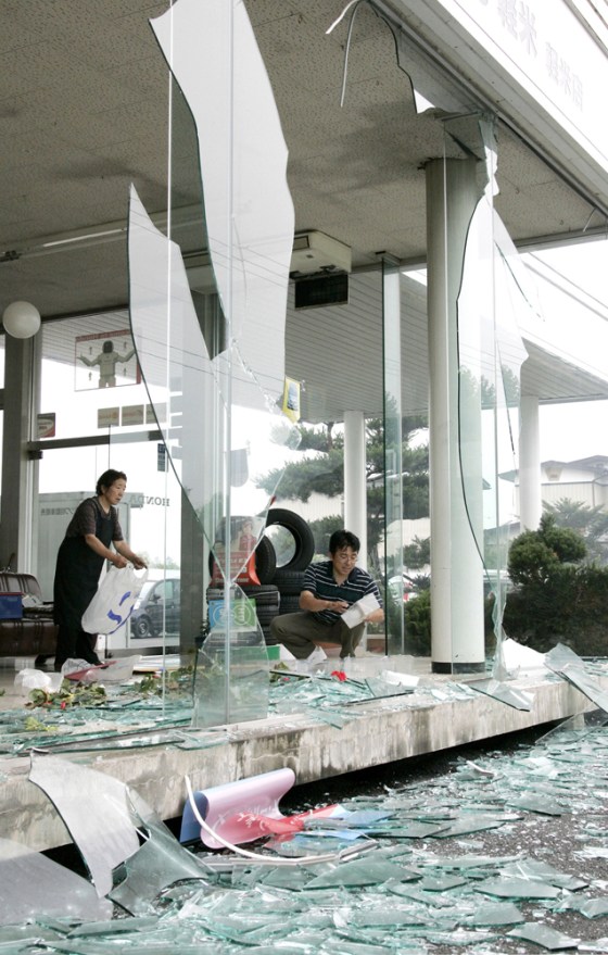 Image: People clean up the pieces of glasses shattered by a strong earthquake