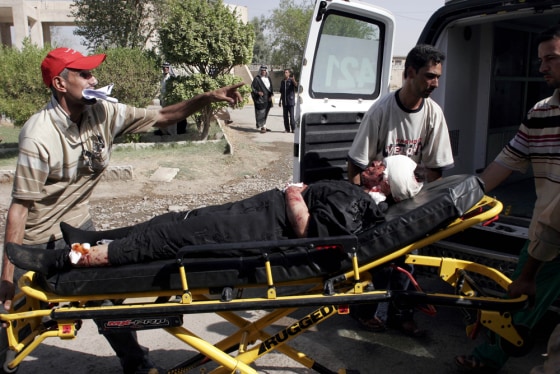 Image: A man injured in a bomb attack is transported into a hospital in Baghdad