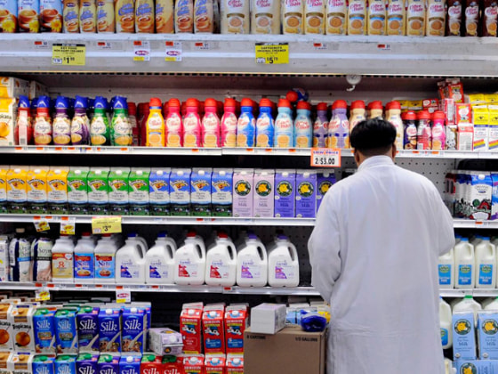 Image:  A man stocks dairy products at a supermarket i