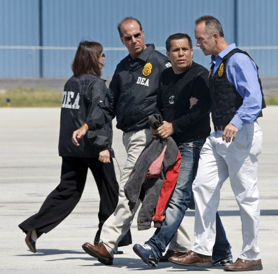 Image: US DEA officers walk with former commander of the United Self Defenses of Colombia