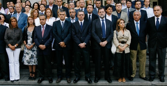 Image: Spanish politicians stand outside city hall to observe five minutes of silence in remembrance of victims of the Spanair plane crash in Madrid