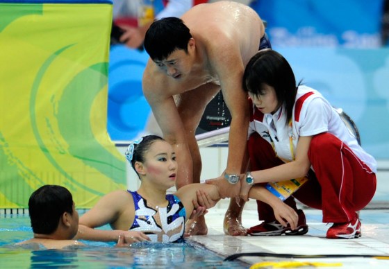 Image: Hiromi Kobayashi of Japan is helped out of the pool