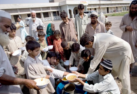 Pakistani people from the Bajur tribal region receive donated food Saturday&nbsp;in a vocational school building&nbsp;on the outskirts of Charsadda, Pakistan. It's one&nbsp;of more than 20 relief camps the government says are for displaced people.