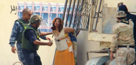 Image: Iraqi police remove a suicide vest from an Iraqi girl