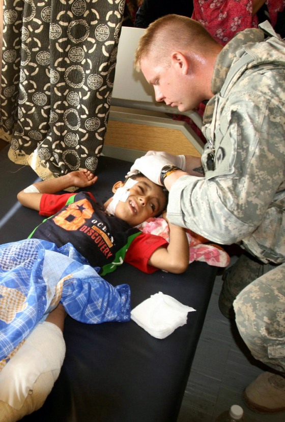 Image: U.S. soldier attends to a boy who was wounded