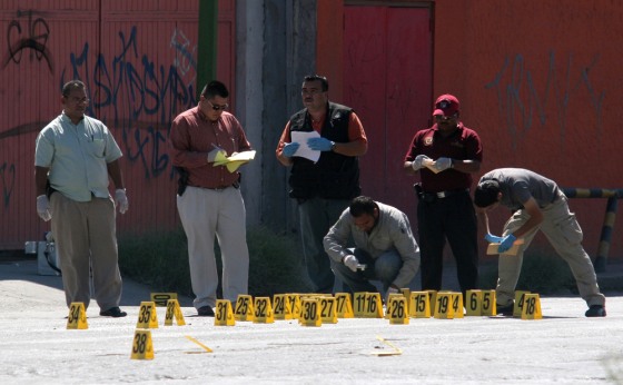 Image: Police inspect crime scene where four men were killed in drive-by shooting in the border city of Ciudad Juarez