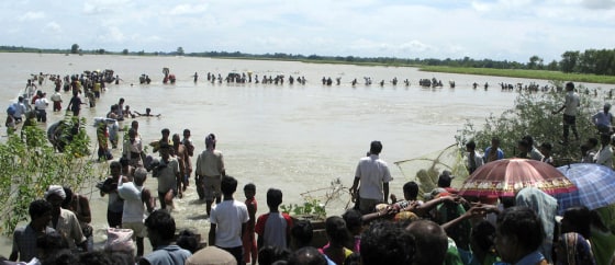 Image: Flood-affected local residents wade through an overflowing Koshi river