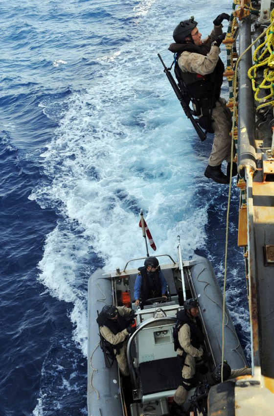 Image: A Canadian Navy sailor climbs on the World Food Programme cargo ship