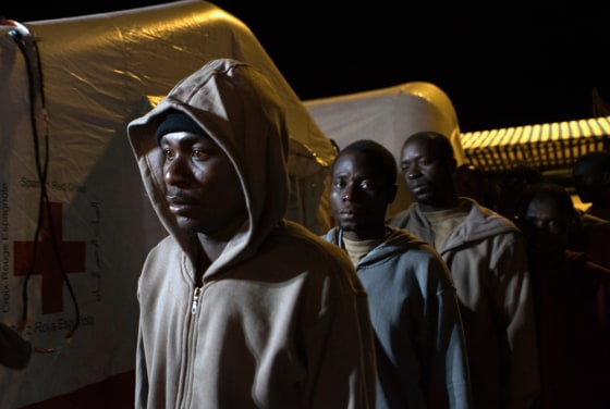 Image: Would-be immigrants stand in line after arriving at the port of Los Cristianos on Spain's Canary island of Tenerife