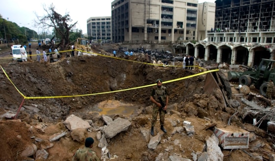 Image: A soldier stands near the bomb crater