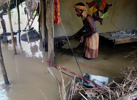 Image: A villager shifts his belongings from his damaged home in a village in India