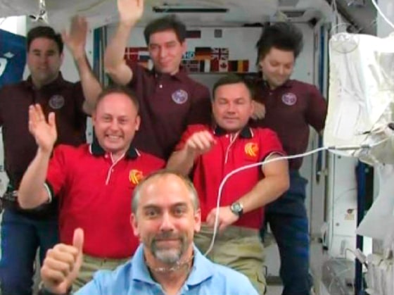 Image: Richard Garriott and the International Space Station crew members wave after crew news conference