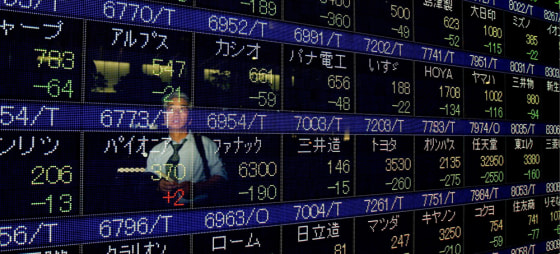 Image: A Japanese businessman looks at a stock price indicator