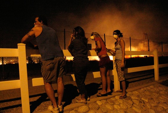 Image: Residents watch as a brush fire burns