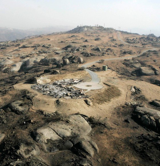 Ruins of a home share the scorched landscape near Ramona, Calif., in this view from Tuesday.