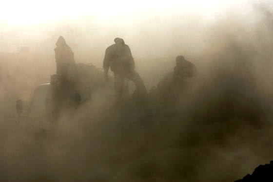 Soot engulfs workers loading coal onto trucks in Baotou, China.