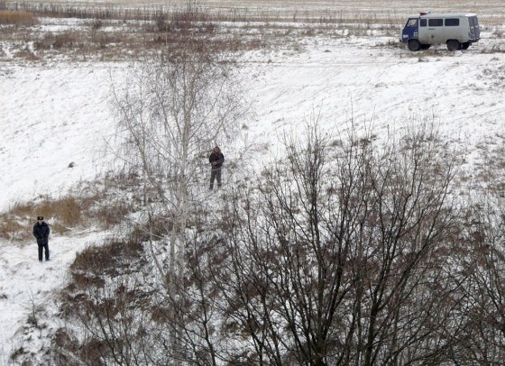 Policemen stand guard on the hillside where cult members are hidden inside a snow-covered cave in the Penza region of central Russia
