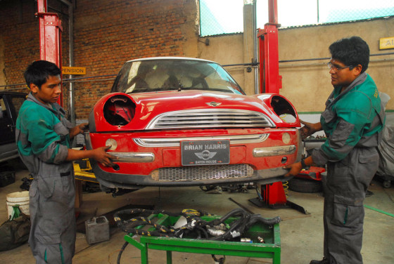 Images: Auto mechanics repair the red Mini Cooper.