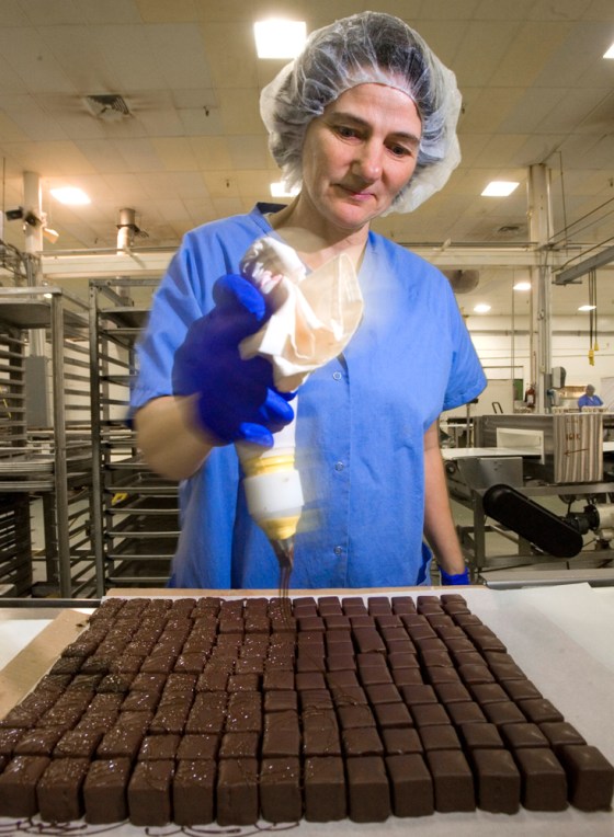 Sandra Bessert decorates petits fours by hand on the line at The Swiss Colony in Monroe, Wis. The catalog company's bakery produces nearly 54 million petits fours per year, with most sold during the Christmas season. 
