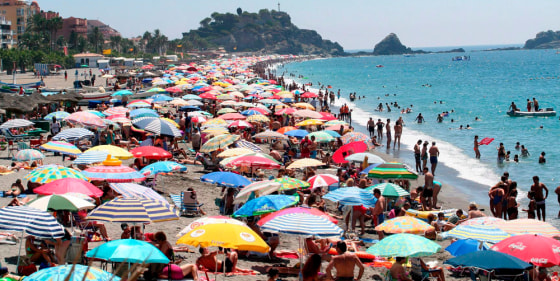 Image: Vacationers crowd the beach of San Cristobal in Almunecar