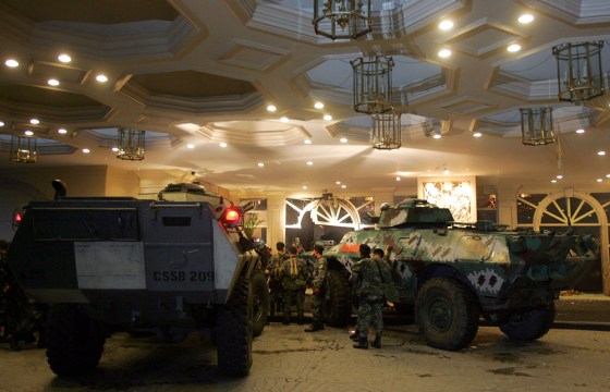 Special forces use an armoured personnel carrier to smash the front door of the Peninsula Hotel during their assault in Makati City