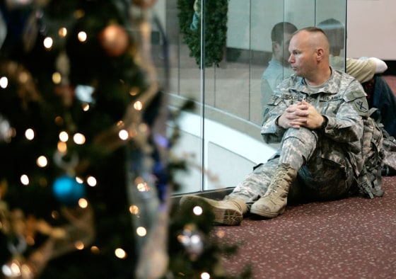 Image: Staff Sgt. Raymond Golden sits near a Christmas tree at the airport in Atlanta.