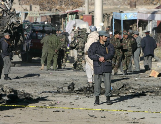 Afghan police officer stands guard at the site of a suicide car bomb blast in Kabul