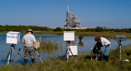 Image: Members of the media once again reset their remote cameras in the swamp area near space Shuttle Atlantis at launch pad 39A