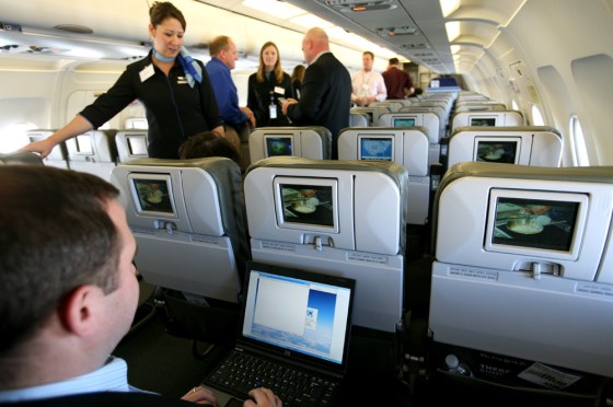 Brad Garlinghouse, left, senior vice president of Yahoo, demonstrates the capabilities of a laptop aboard an Airbus A320 aircraft equipped with a wireless network. JetBlue Airways Corp. began offering free online messaging services on one of its planes, becoming among the first airlines to offer in-flight Internet access. 