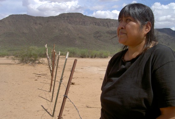 Image: Tribal elder Ofelia Rivas stands at a rusted fence marking the Arizona.-Mexico border on the Tohono O'odham Nation.
