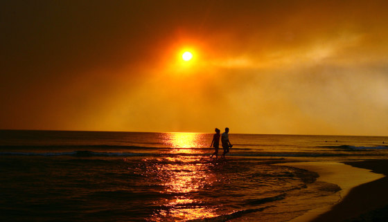 Image: People walk along a beach in Zacharo