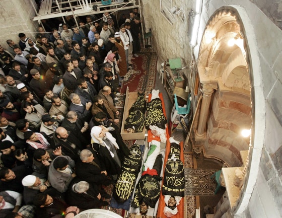 Palestinians pray beside the bodies of Islamic Jihad militants after they were killed by Israeli air strikes in Gaza