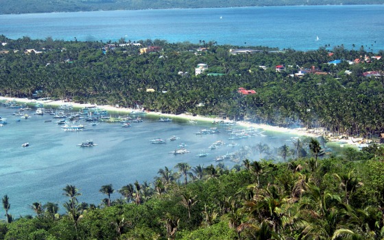Image: Boats float off the famous \"white beach\" of the central Philippine island of Boracay
