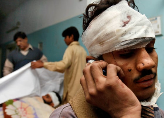 Image: An injured victim of a derailed train talks on his mobile phone at a local hospital in Mehrabpur.