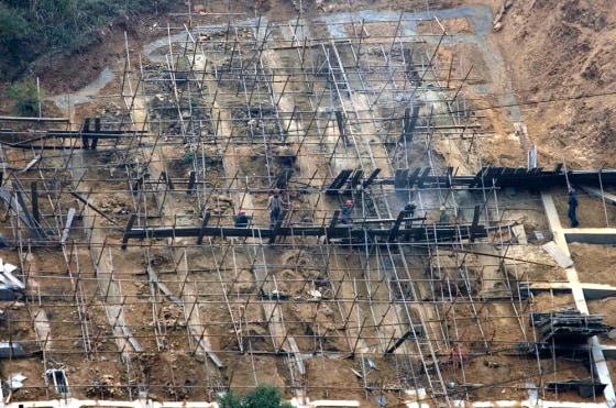 Image: Workers reinforce a hillside along the Yangtze River upstream from the three Gorges Dam